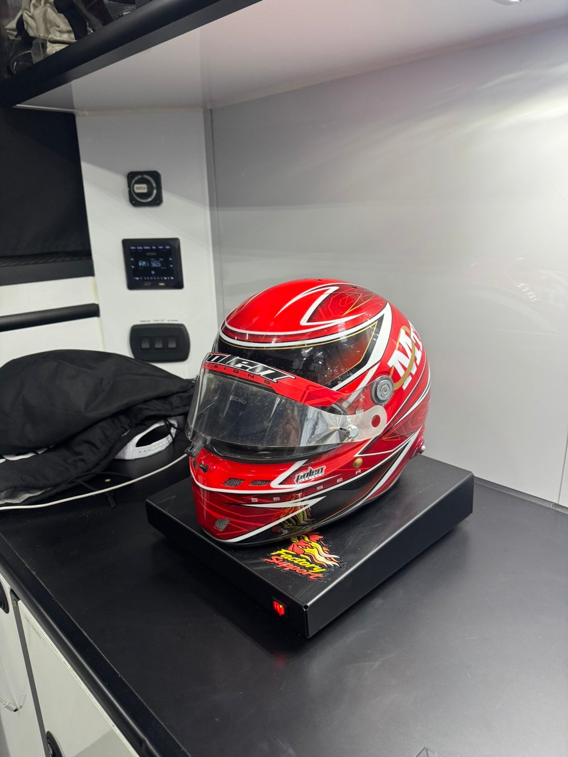 Red racing helmet on Factory Support V1 Helmet Dryer in trailer